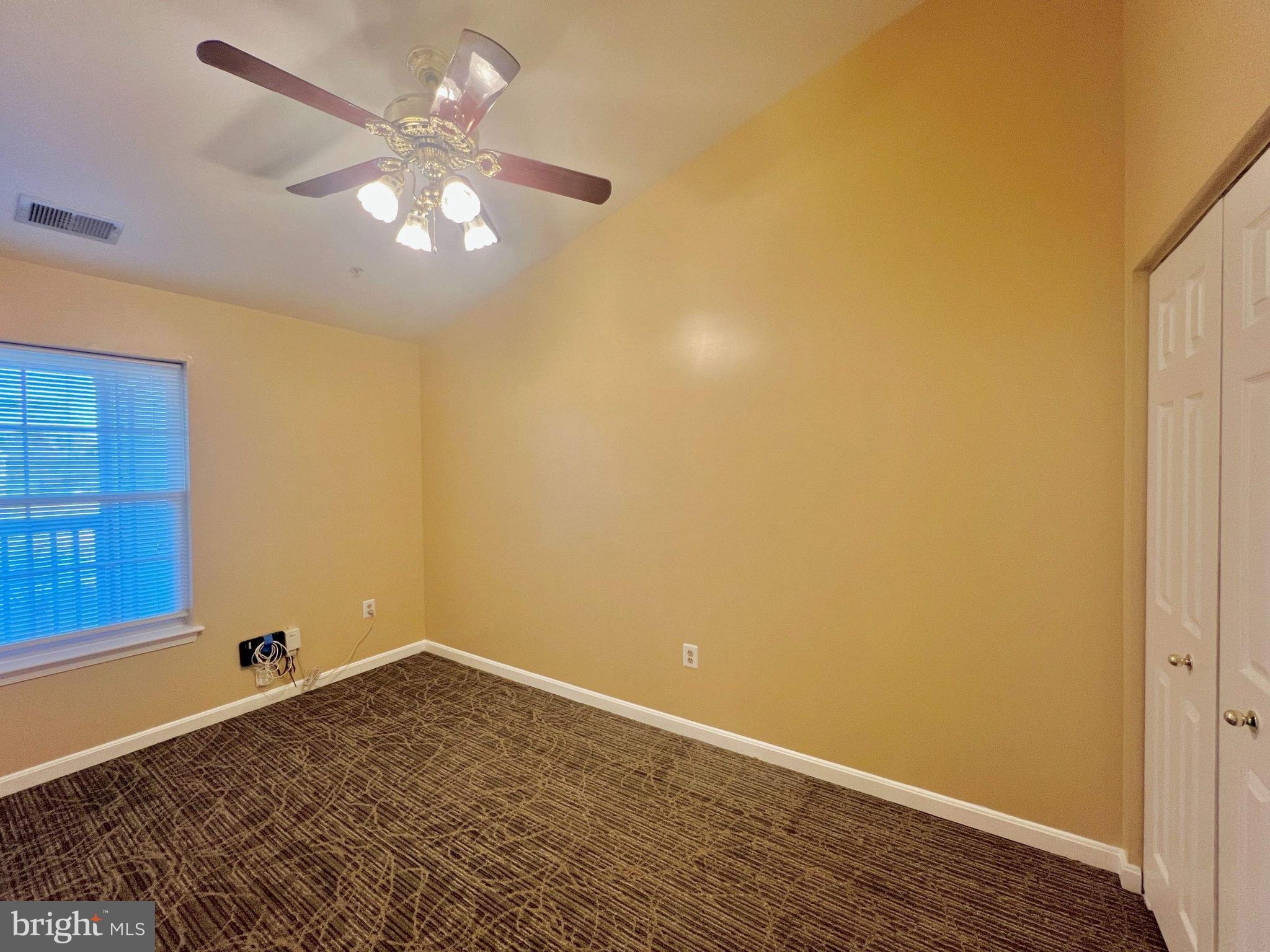 6502 Home Water Court, Unit 303 Glen Burnie, MD 21060 - Photo 12 of 14 en empty room with wooden floor and fan