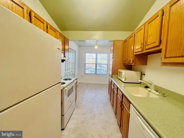 a kitchen with a sink and wooden floor