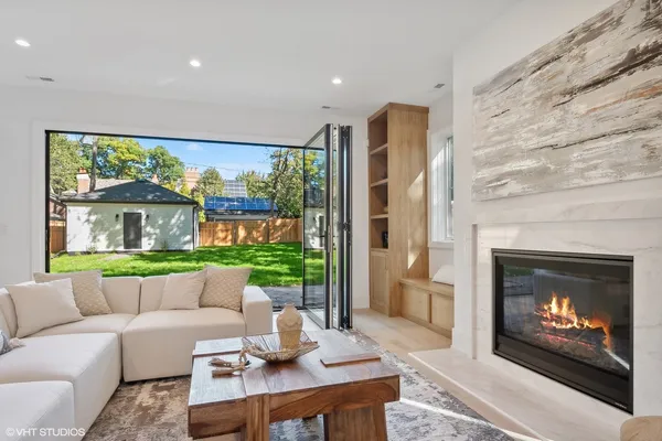 a living room with furniture a fireplace and a floor to ceiling window