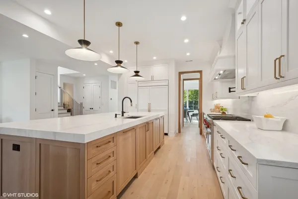 a large kitchen with kitchen island a sink a center island a stove and a cabinets