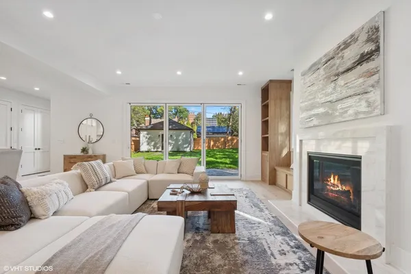 a living room with furniture fireplace and a large window