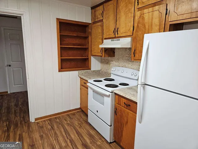 a kitchen with a stove a refrigerator and a cabinets