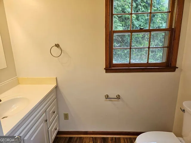 a bathroom with a granite countertop sink mirror vanity and toilet