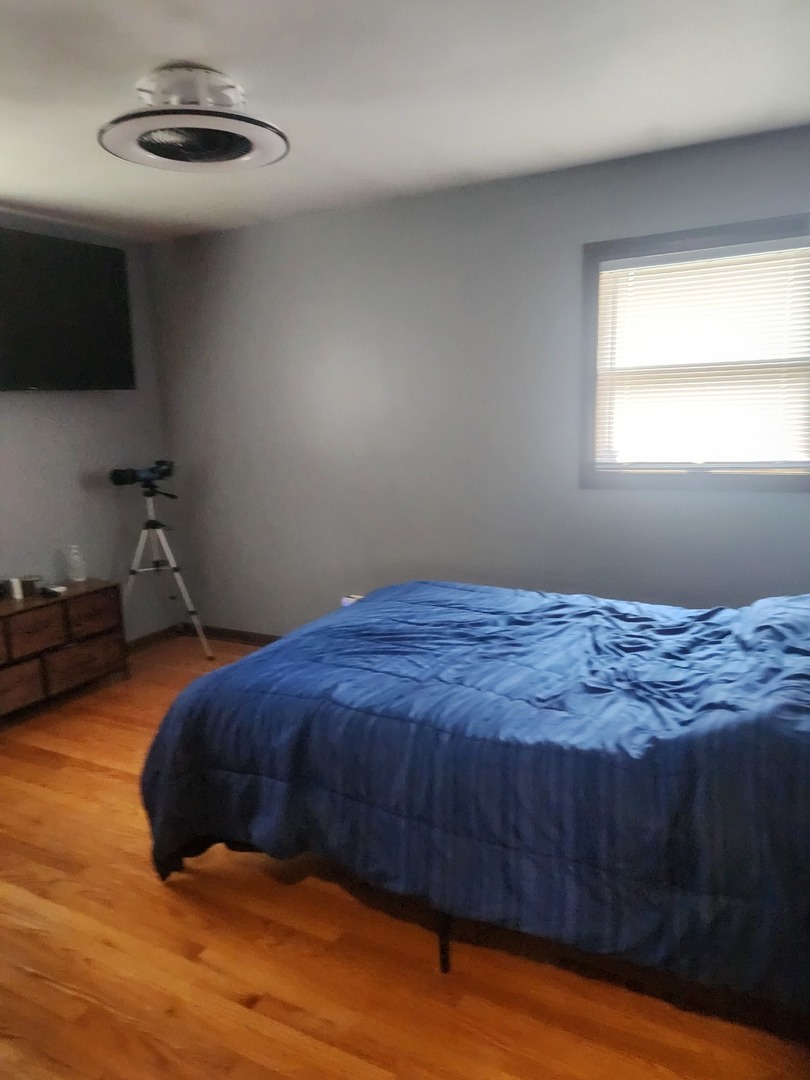 Undisclosed Address Lansing, IL 60438 - Photo 7 of 16 a bedroom with a bed and a wooden floor