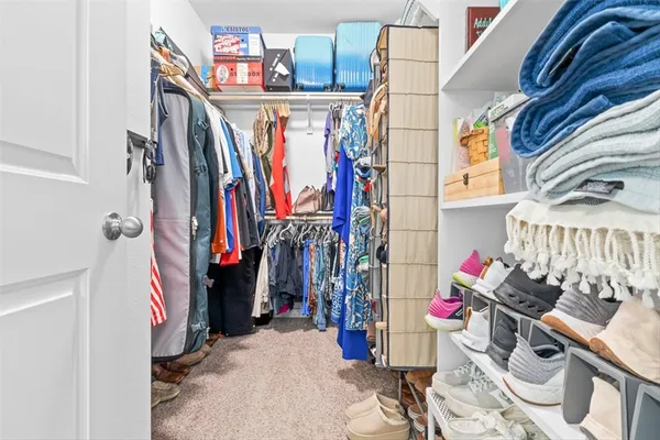 a view of walk in closet with clothes