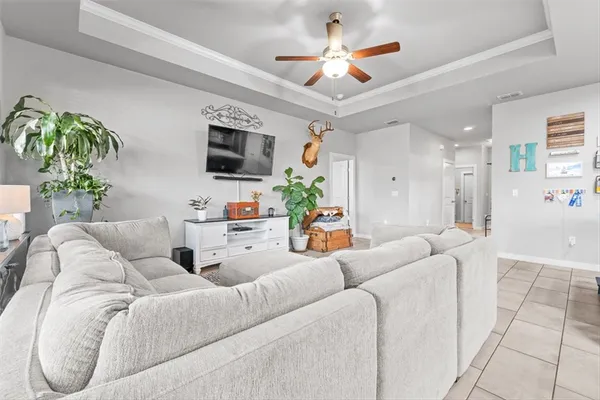a living room with furniture a flat screen tv and a chandelier
