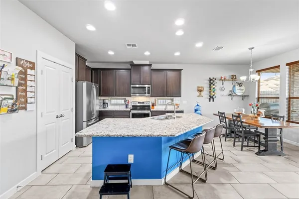 a large kitchen with lots of counter space and furniture