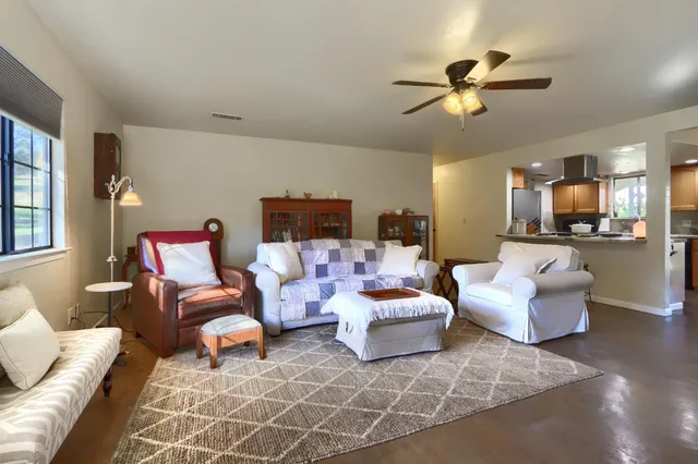 a living room with furniture and a view of kitchen