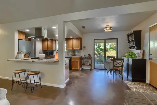 a kitchen with a table chairs refrigerator and cabinets