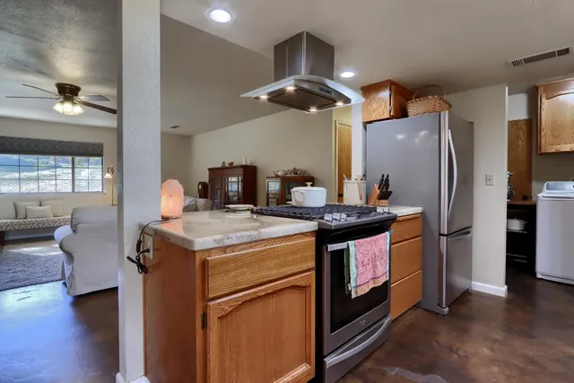 a kitchen with stainless steel appliances granite countertop a stove a refrigerator and a refrigerator