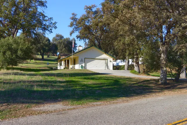 a front view of a house with a yard and trees