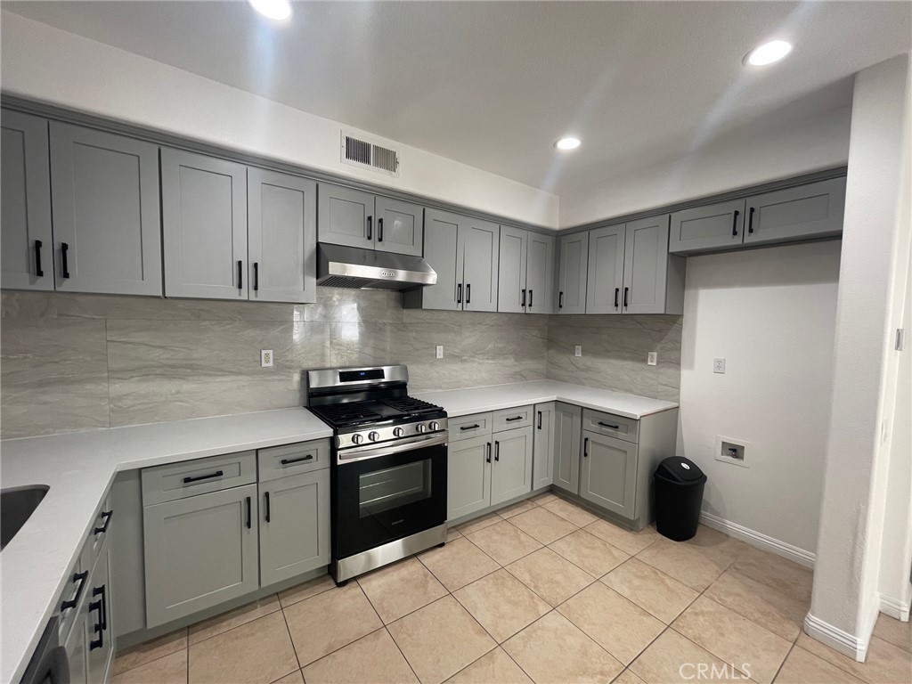 4520 Filson Street Riverside, CA 92507 - Photo 11 of 29 a kitchen with white cabinets and appliances