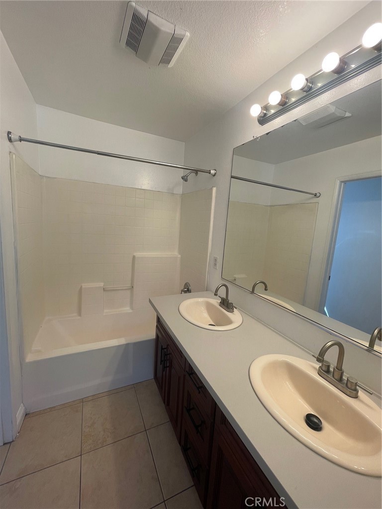 4520 Filson Street Riverside, CA 92507 - Photo 27 of 29 a bathroom with a sink double vanity granite tub shower and a mirror