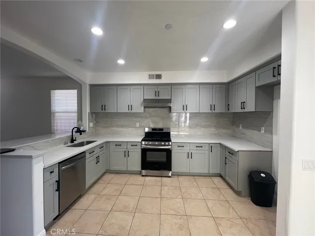 a kitchen with a stove sink and cabinets