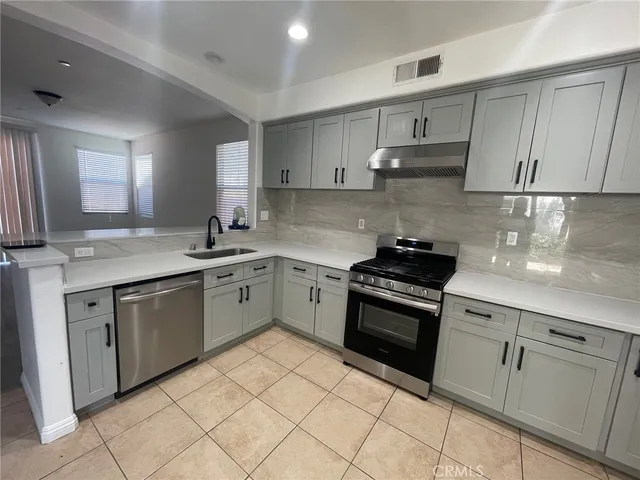 a kitchen with cabinets appliances and a sink