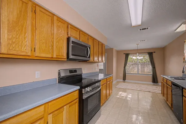 a kitchen with stainless steel appliances granite countertop a stove a sink and a microwave