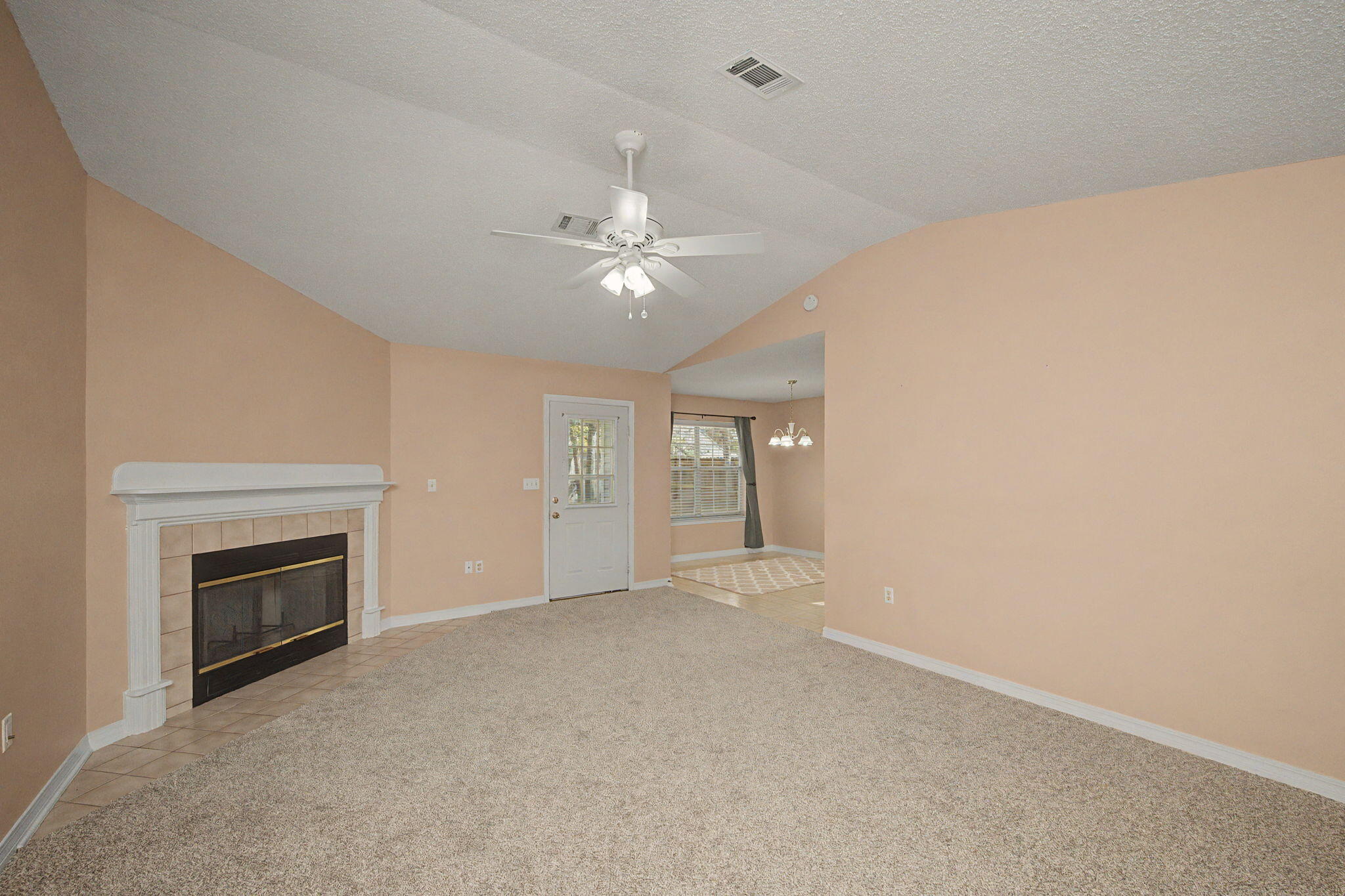 223 Runnymeade Drive Crestview, FL 32539 - Photo 7 of 38 an empty room with chandelier fan and fireplace