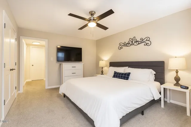 a spacious bedroom with a bed and a flat screen tv