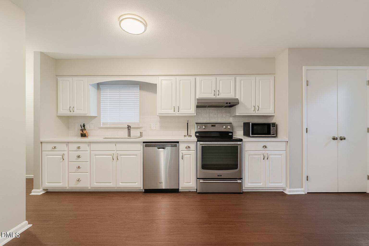 677 Pine Ridge Place, Unit 677 Raleigh, NC 27609 - Photo 7 of 9 a kitchen with white cabinets and white appliances