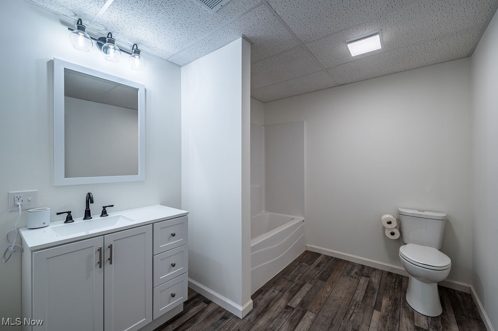 7343 Lost Pavement Road Belleville, WV 26133 - Photo 32 of 49 Full bathroom featuring vanity, dark wood finished floors, a paneled ceiling, and bathtub / shower combination