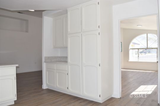 1132 West Robert Avenue Ridgecrest, CA 93555 - Photo 14 of 38 a view of an empty room with wooden floor and a window