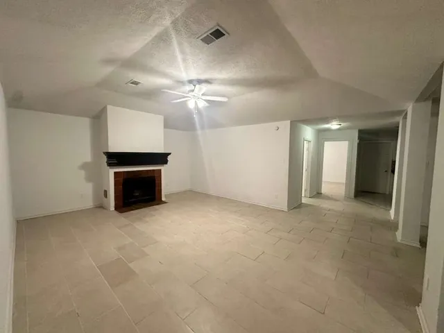 an empty room with a fireplace and fan