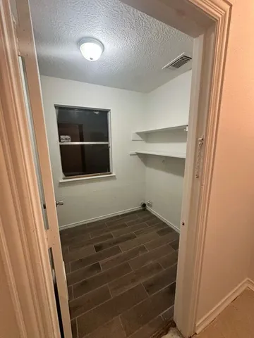 a view of a hallway with wooden floor and entryway