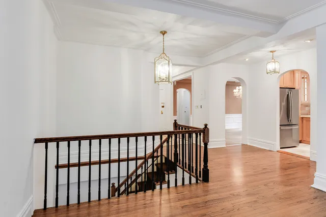 a view of a hallway with wooden floor and stairs