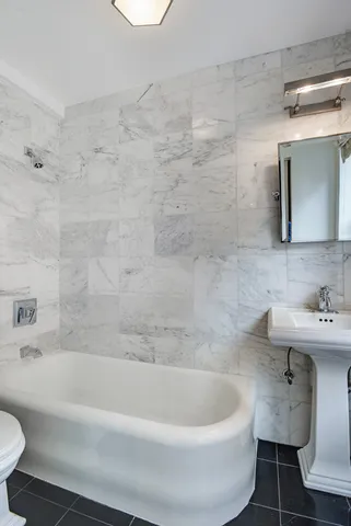 a white bath tub sitting next to a white toilet and sink