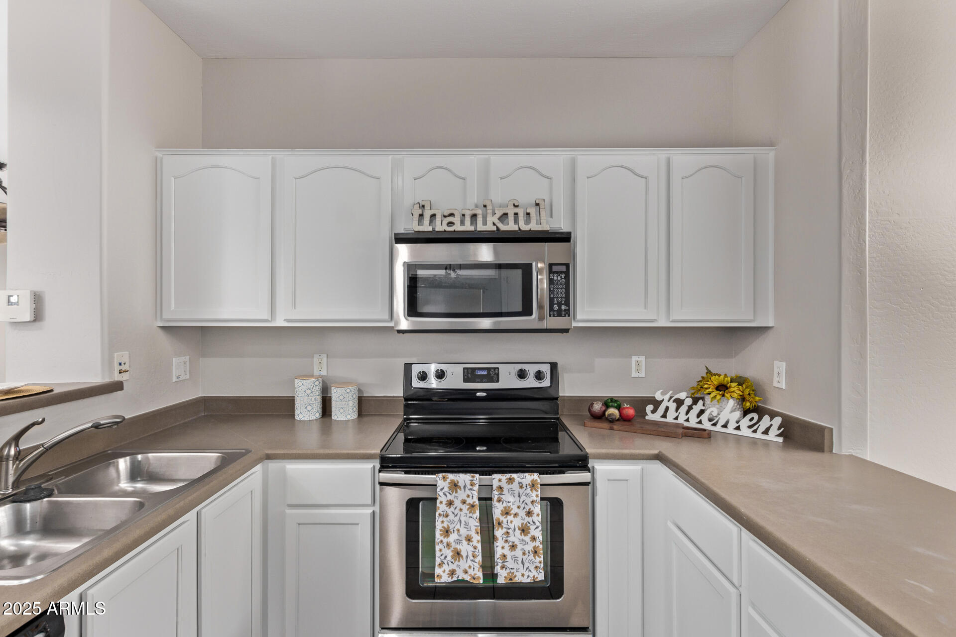 10225 West Camelback Road, Unit 3 Phoenix, AZ 85037 - Photo 13 of 41 a kitchen with stainless steel appliances a stove a sink and a microwave