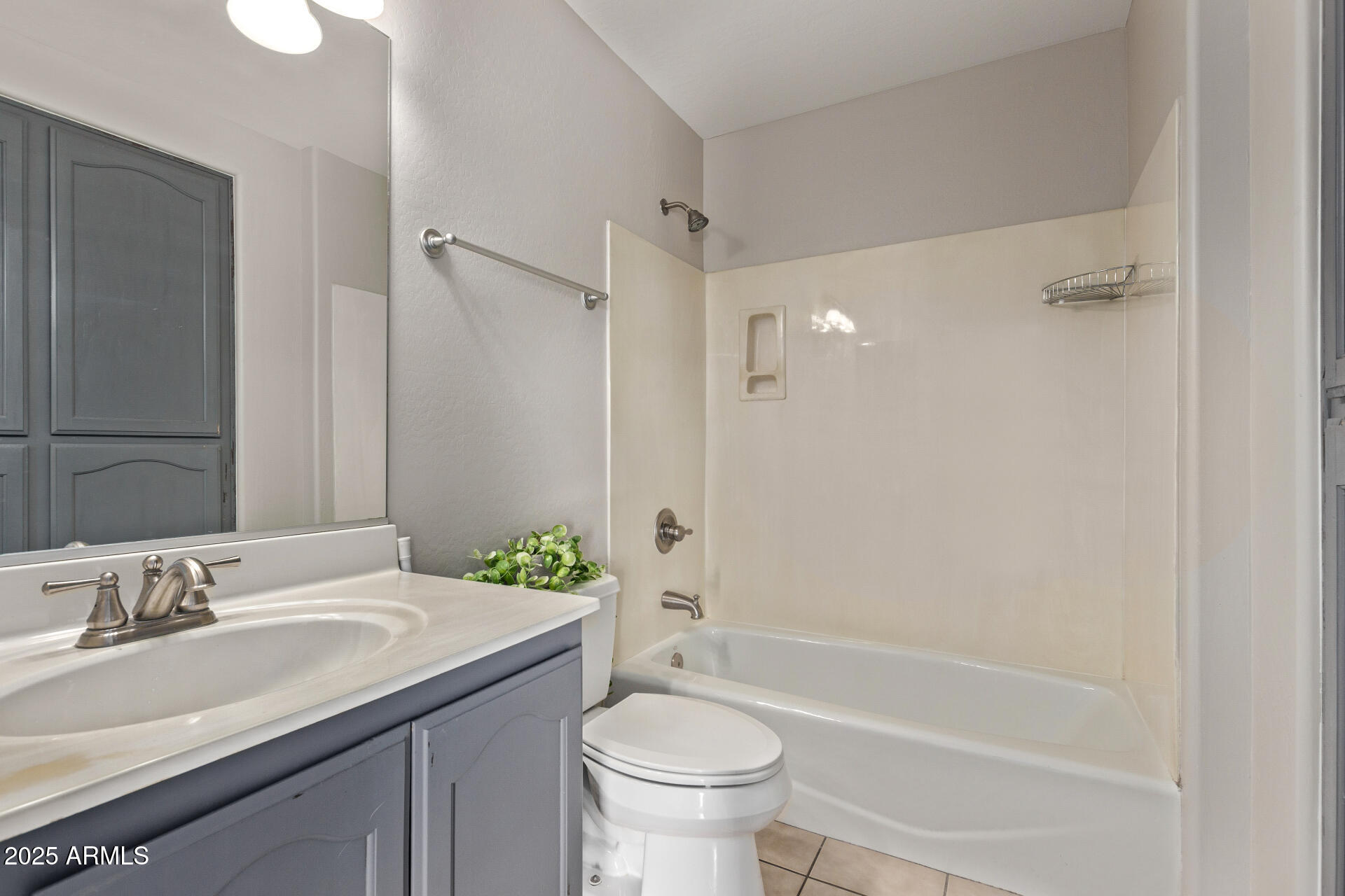 10225 West Camelback Road, Unit 3 Phoenix, AZ 85037 - Photo 27 of 41 a bathroom with a granite countertop sink a toilet a mirror and shower