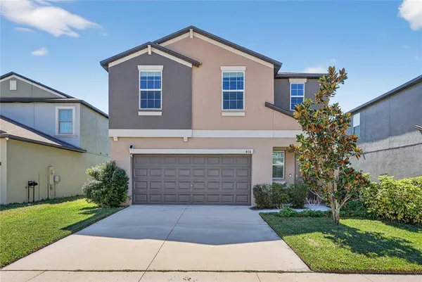 a front view of a house with a yard and garage