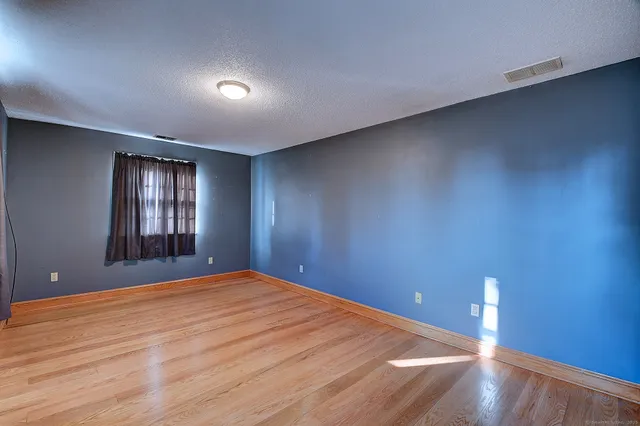 a view of an empty room with wooden floor