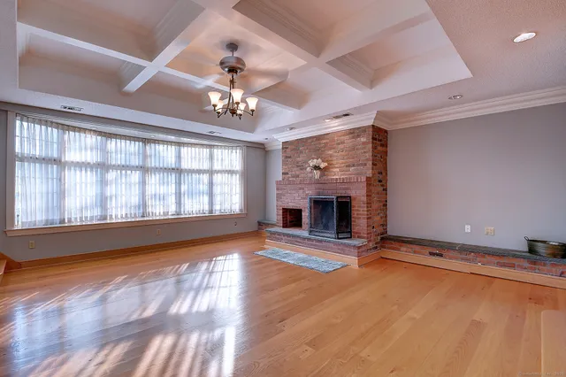 a view of an empty room with a fireplace and a window