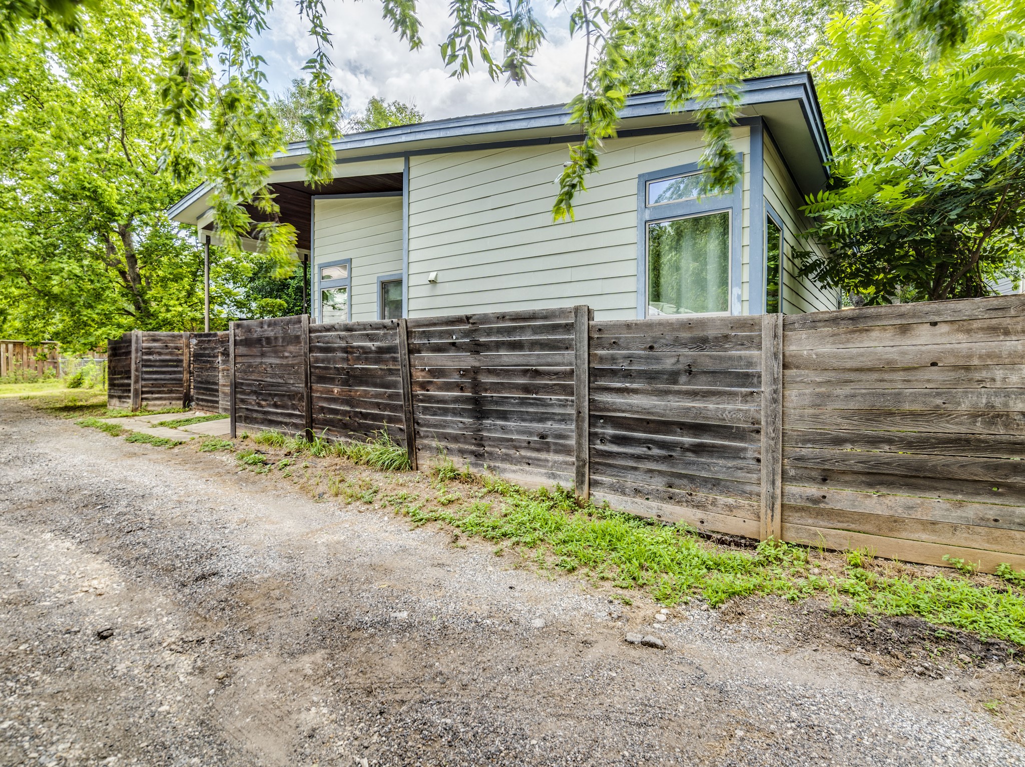 1404 Singleton Avenue, Unit B Austin, TX 78702 - Photo 21 of 21 An inviting exterior with horizontal siding and ample privacy fencing, surrounded by mature trees.