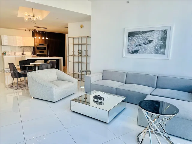 a living room with furniture and kitchen view