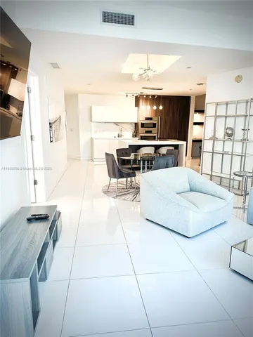 a living room with a couch and a dining table with wooden floor