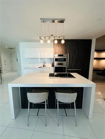 a kitchen with a sink chairs and cabinets