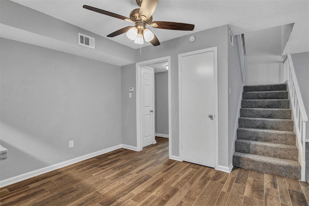 11311 Audelia Road, Unit 221 Dallas, TX 75243 - Photo 7 of 22 a view of an empty room with wooden floor and a ceiling fan