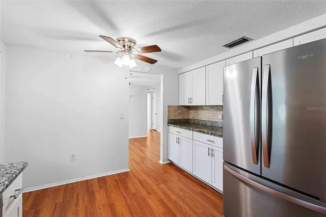 a kitchen with a refrigerator a sink and cabinets