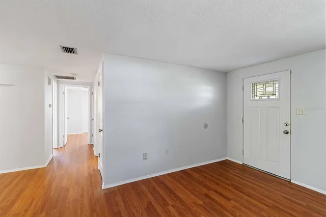 a view of an empty room with wooden floor