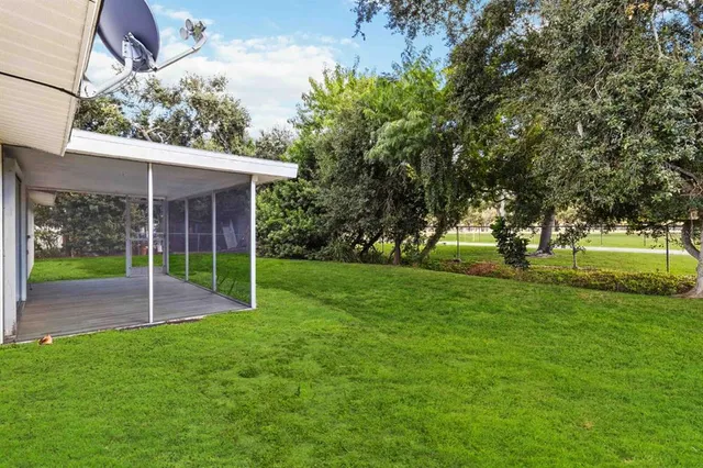 a view of a house with a yard and tree s