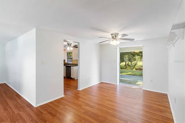 a view of a kitchen with wooden floor and a ceiling fan