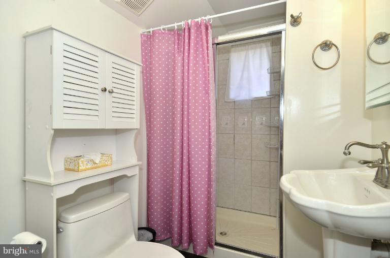 6911 Gilbert Street Springfield, VA 22150 - Photo 20 of 30 a bathroom with a sink a toilet and shower curtain