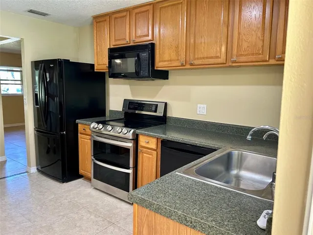 a kitchen with stainless steel appliances granite countertop a stove a refrigerator and a sink