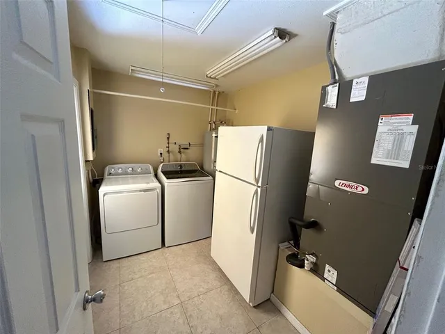 a view of storage and utility room with refrigerator and washer