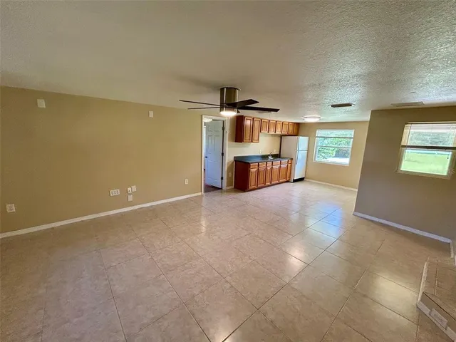 an empty room with kitchen view