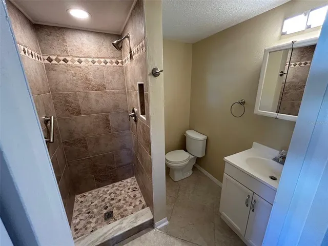 a bathroom with a sink a toilet a shower and a mirror