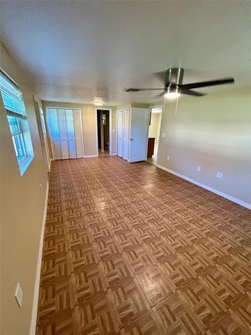 a view of empty room with wooden floor