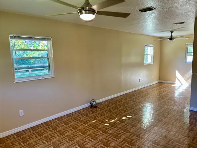 a view of empty room with wooden floor